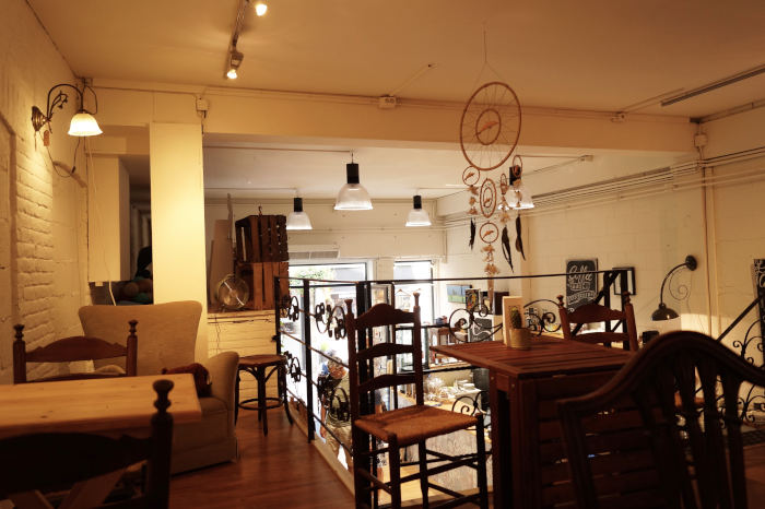 Die Caféecke in dem Geschäft Oila. Gemütliche Tische und Stühle stehen auf der kleinen Tribüne um dort Kaffee zu trinken.